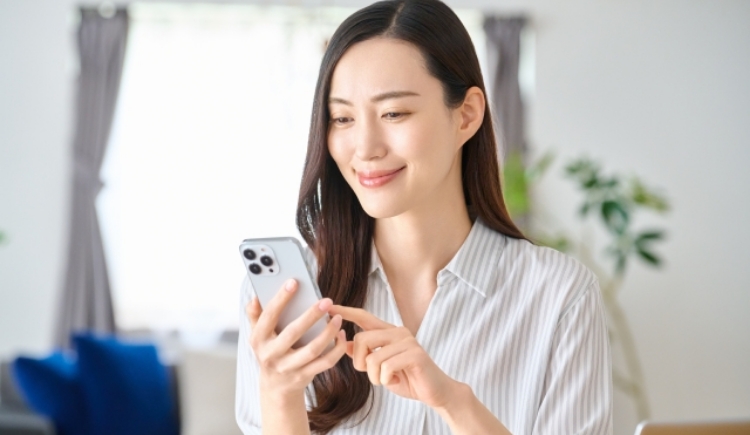 スマートフォンで予約する女性